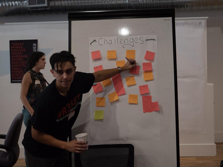 A facilitator adds a note to the Challenges board
